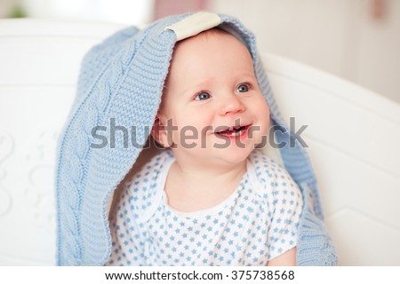 stock-photo-smiling-baby-boy-year-old-sitting-in-bed-with-knitted-cover-on-looking-away-childhood-375738568.jpg